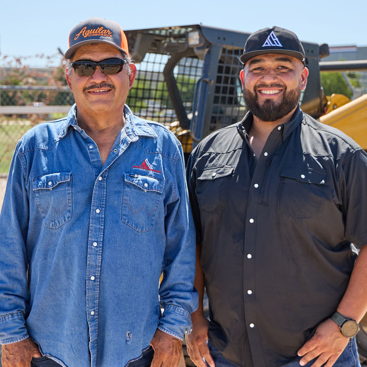 Two men, Benny and Leno Aguilar, stand side by side at a construction site.